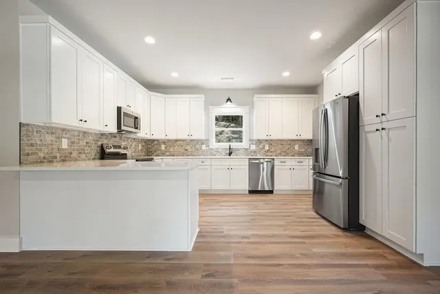 a kitchen with granite countertop white cabinets and stainless steel appliances