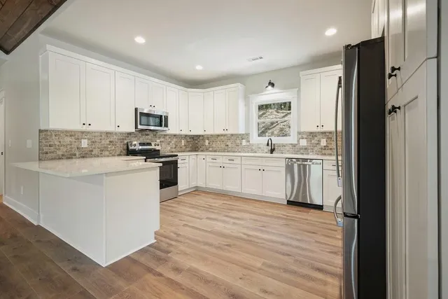 a kitchen with white cabinets white appliances and sink
