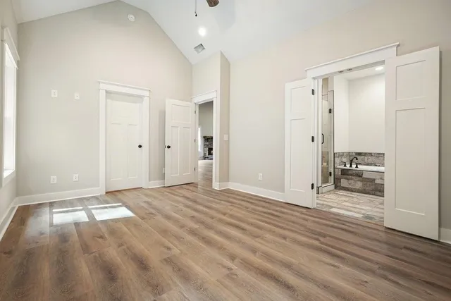an empty room with wooden floor and mirror
