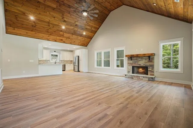 a view of empty room with fireplace and wooden floor