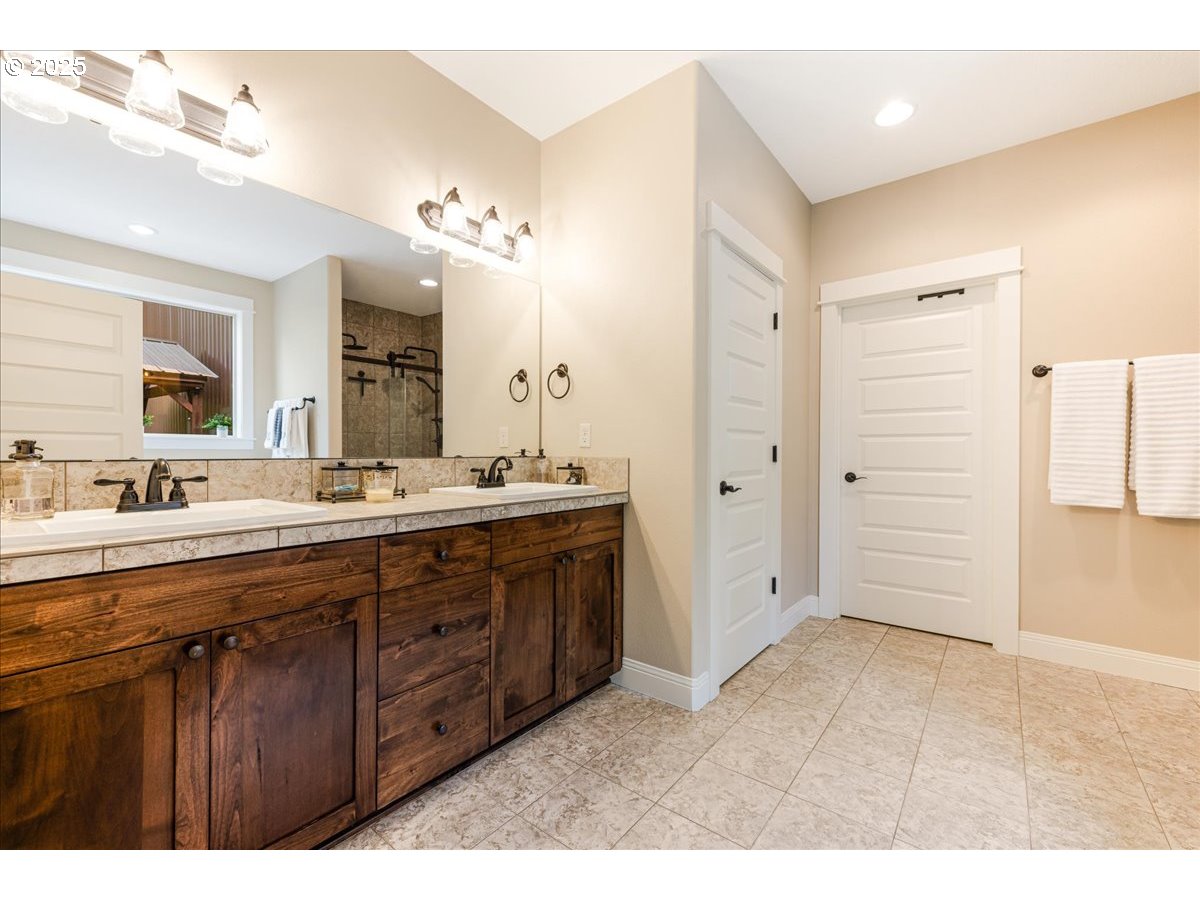45632 Northwest Mead Way Banks, OR 97106 - Photo 14 of 48 a bathroom with a double vanity sink a large mirror and a shower