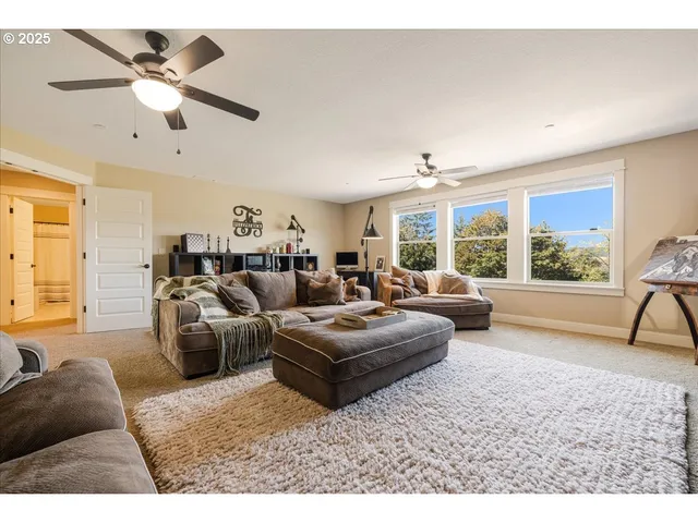 a living room with furniture and a large window with garden view