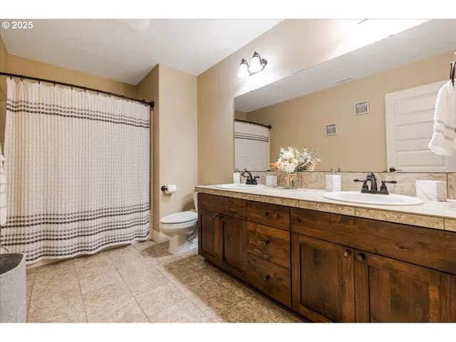 a bathroom with a double vanity sink a toilet and a mirror