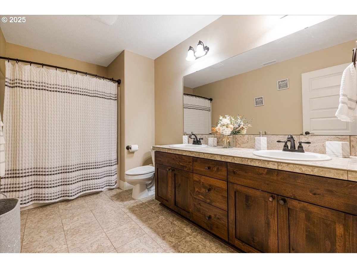 45632 Northwest Mead Way Banks, OR 97106 - Photo 22 of 48 a bathroom with a double vanity sink a toilet and a mirror