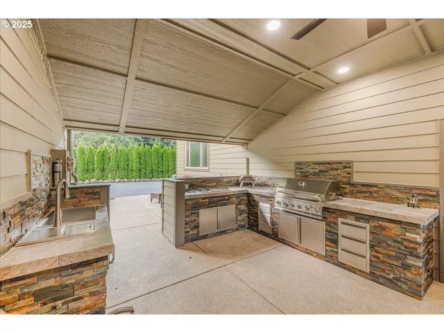 a kitchen with stainless steel appliances granite countertop a stove a sink and a microwave