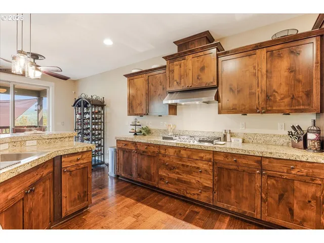 a kitchen with granite countertop a sink cabinets and stainless steel appliances