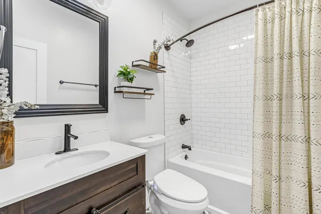 a bathroom with a sink a toilet a mirror and shower