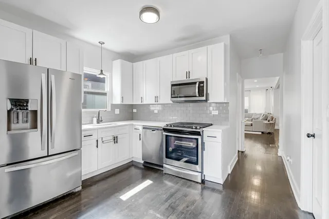 a kitchen with stainless steel appliances a refrigerator sink and microwave