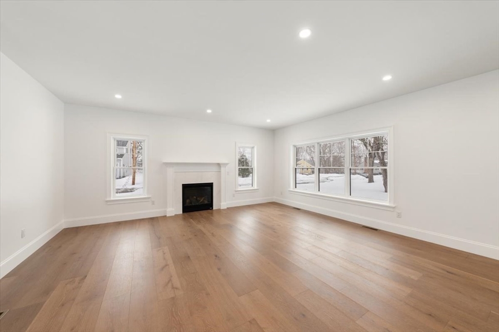 37 Longfellow Road Natick, MA 01760 - Photo 7 of 25 an empty room with wooden floor fireplace and windows