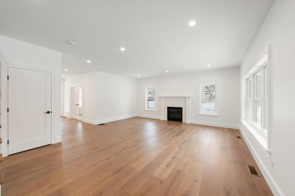 37 Longfellow Road Natick, MA 01760 - Photo 8 of 25 an empty room with wooden floor fireplace and windows