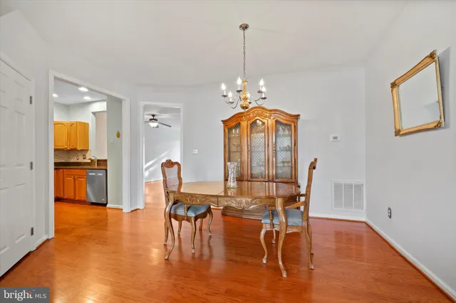 a dining room with furniture a chandelier and wooden floor
