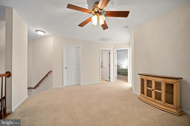 an empty room with ceiling fan and window