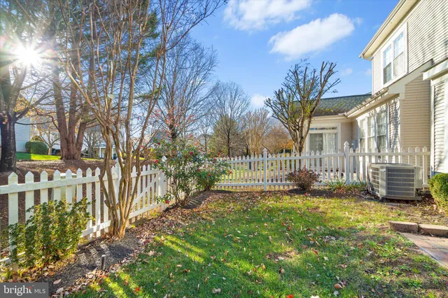 a view of a house with a small yard and wooden fence