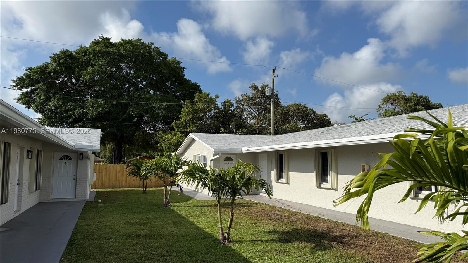 220 Northwest 12th Street Pompano Beach, FL 33060 - Photo 1 of 77 a view of a white house with a big yard and a garden
