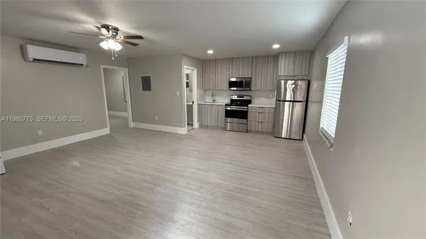 a kitchen with stainless steel appliances granite countertop a refrigerator a microwave a sink and a cabinets