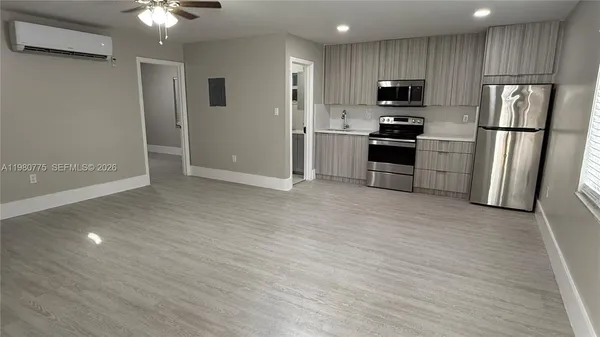a kitchen with granite countertop a refrigerator and a stove top oven