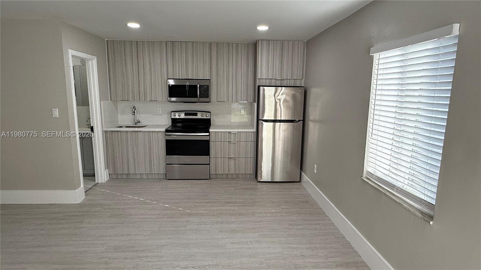 220 Northwest 12th Street Pompano Beach, FL 33060 - Photo 17 of 77 a kitchen with stainless steel appliances a refrigerator and a stove top oven
