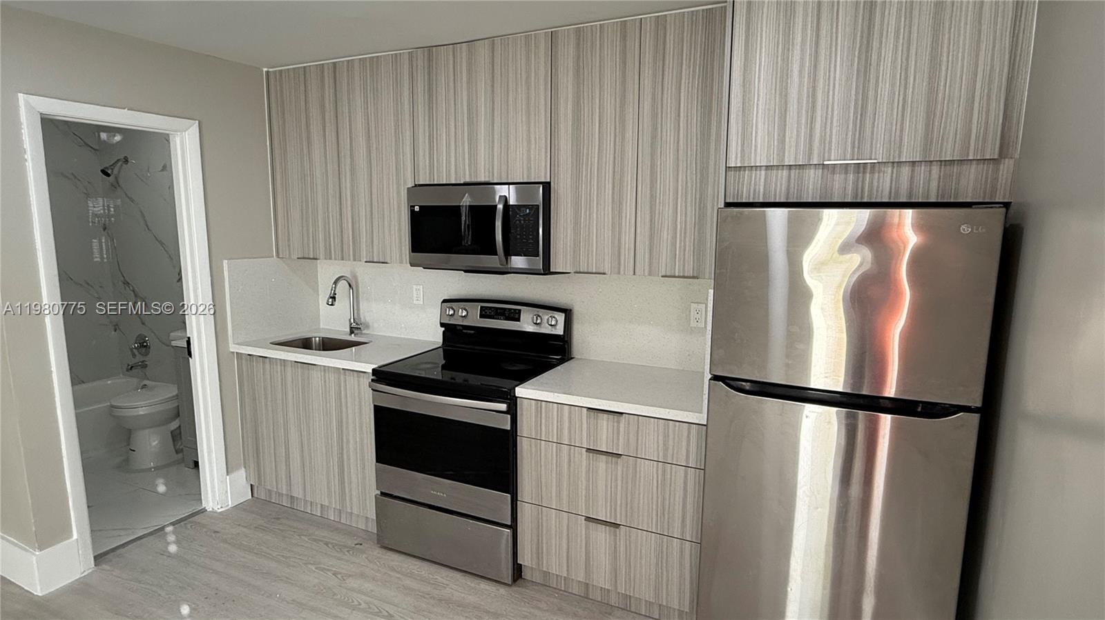 220 Northwest 12th Street Pompano Beach, FL 33060 - Photo 18 of 77 a kitchen with stainless steel appliances granite countertop a refrigerator a microwave a sink and a cabinets