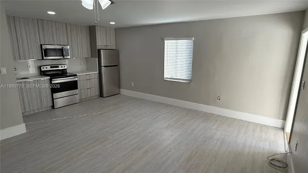 an empty room with wooden floor and closet area