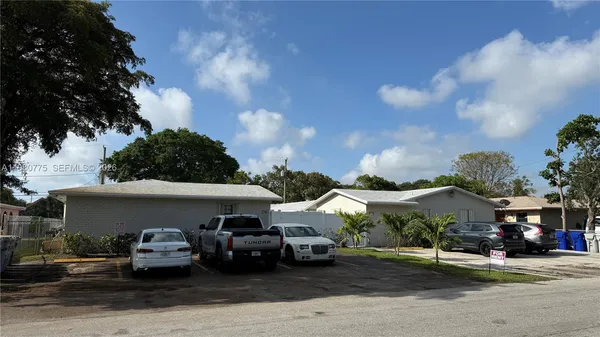 a front view of a house with cars parked