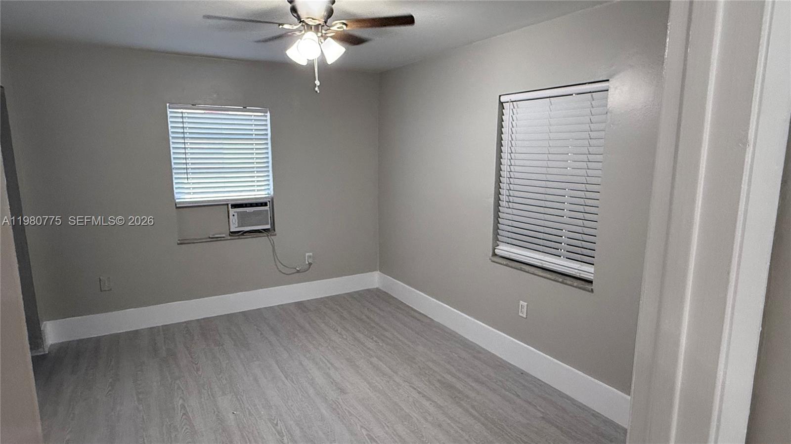 220 Northwest 12th Street Pompano Beach, FL 33060 - Photo 22 of 77 a view of an empty room with wooden floor and a window