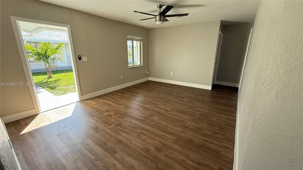 an empty room with wooden floor and entrance