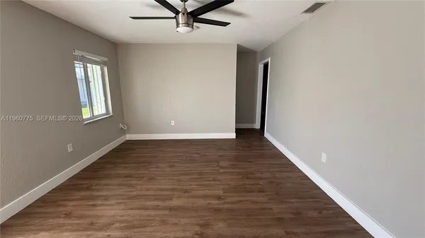 wooden floor in an empty room with a window