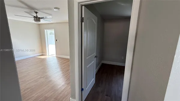 an empty room with windows and chandelier fan