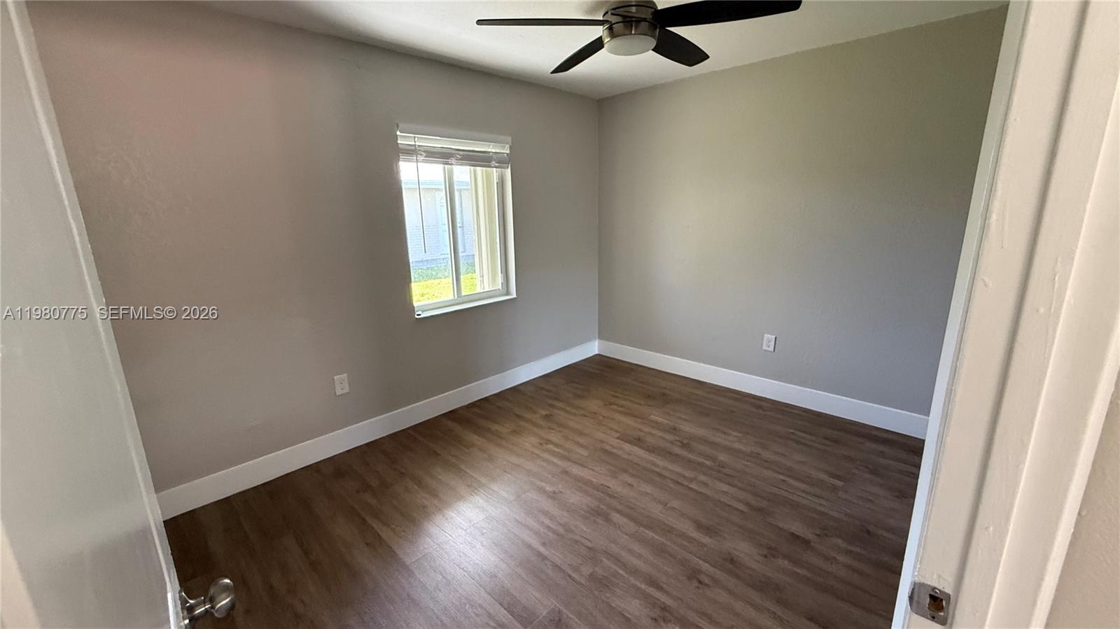 220 Northwest 12th Street Pompano Beach, FL 33060 - Photo 41 of 77 an empty room with wooden floor and windows