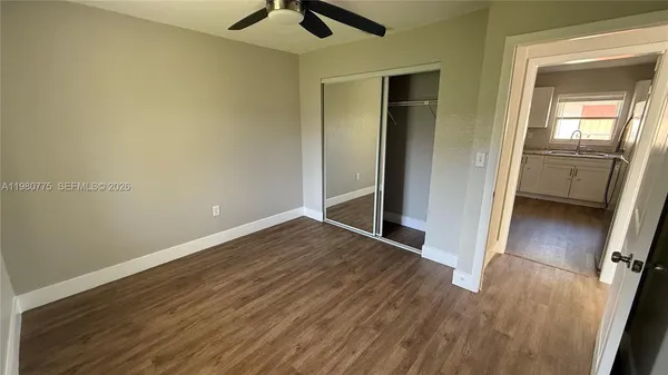 an empty room with a window and a fan