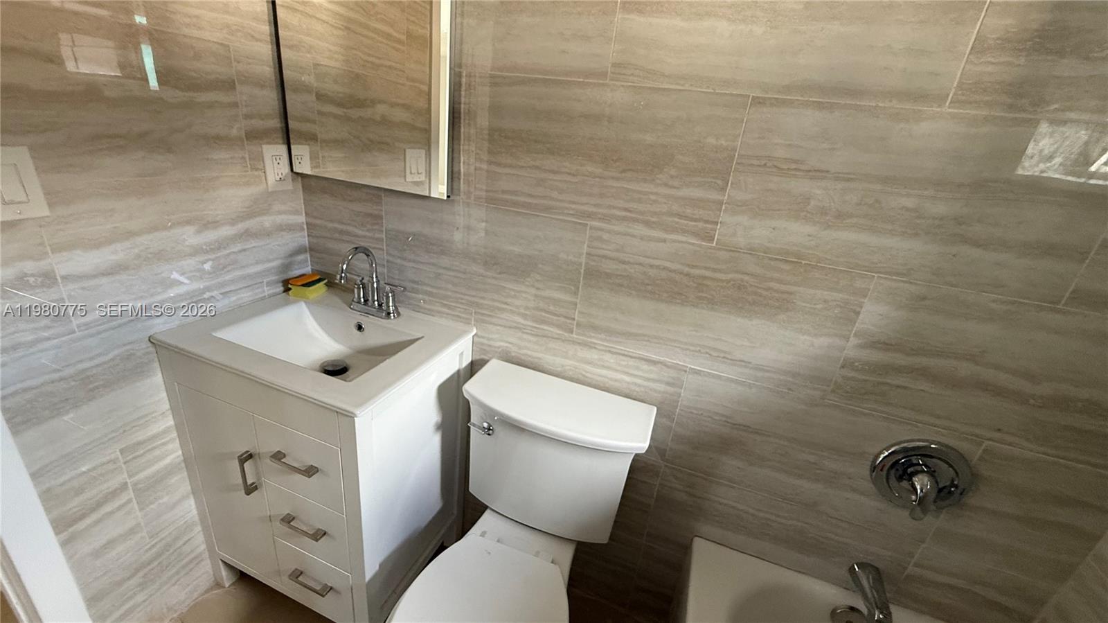 220 Northwest 12th Street Pompano Beach, FL 33060 - Photo 68 of 77 a bathroom with a sink a toilet and a mirror
