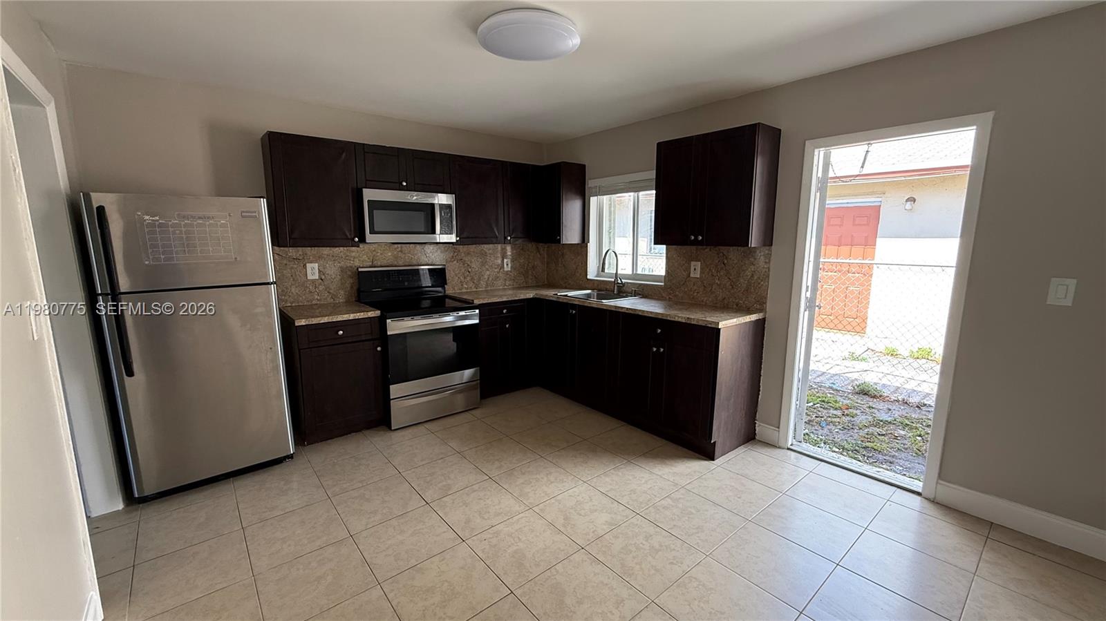 220 Northwest 12th Street Pompano Beach, FL 33060 - Photo 74 of 77 a kitchen with stainless steel appliances granite countertop a refrigerator stove and microwave