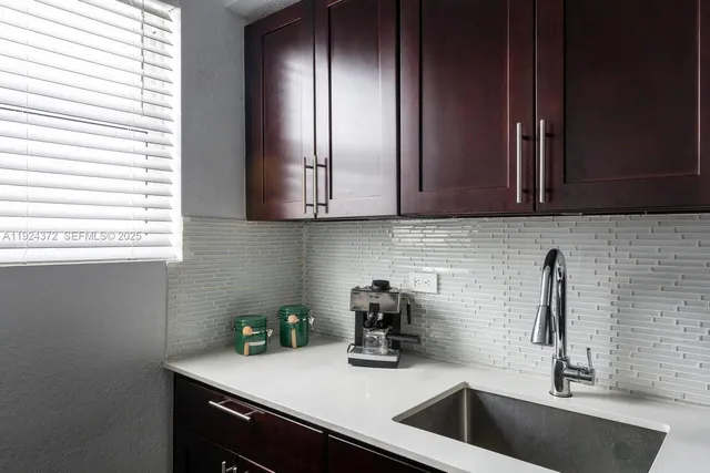 a kitchen with a sink cabinets and window