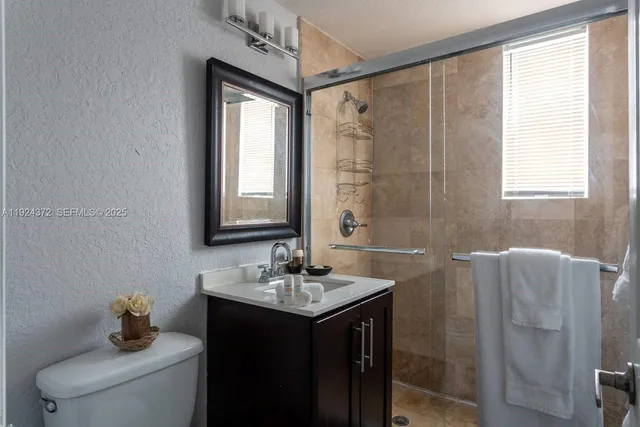 a bathroom with a sink toilet and shower