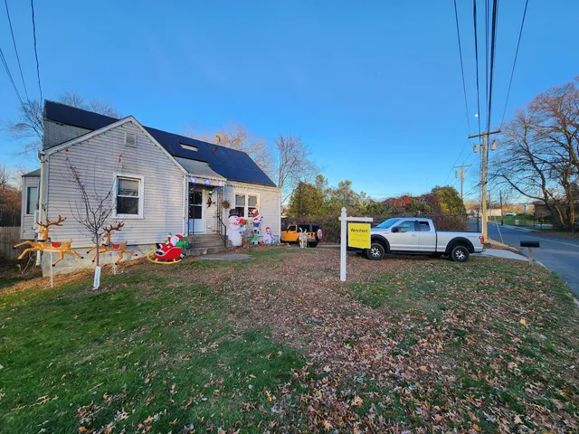 a front view of a house with cars parked