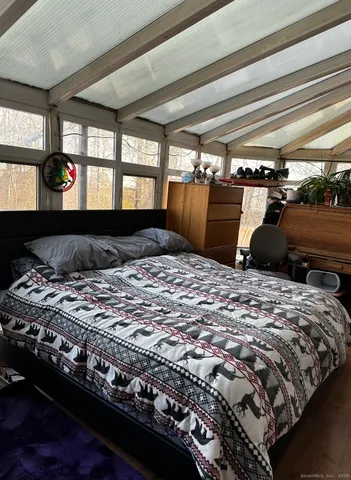 a bedroom with a bed and wooden floor