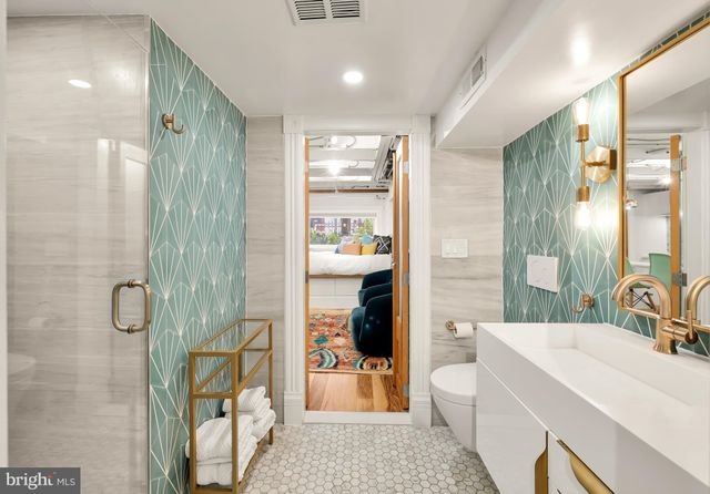 a kitchen with stainless steel appliances a refrigerator a sink and white cabinets