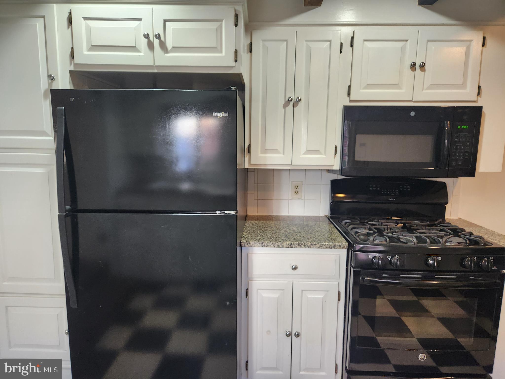 316 Princess Anne Street Fredericksburg, VA 22401 - Photo 14 of 44 a kitchen with granite countertop a refrigerator a stove a microwave and cabinets