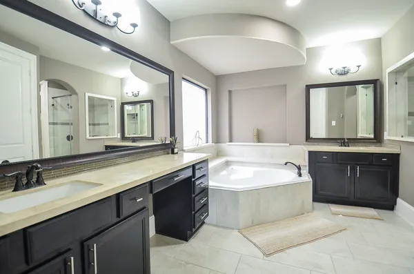 a spacious bathroom with a sink a large mirror and a bathtub