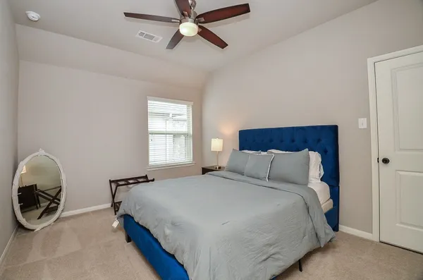 a bedroom with a bed a window and gym equipment