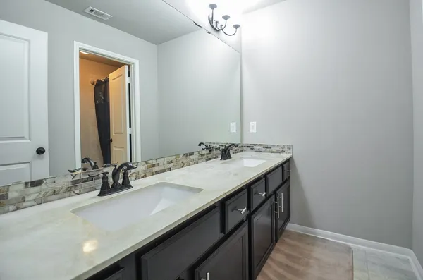 a bathroom with a double vanity sink and a mirror