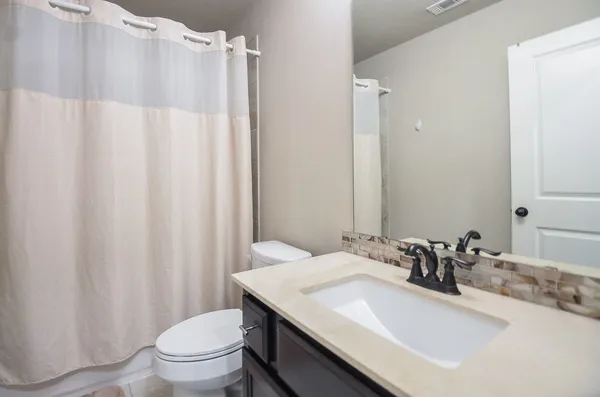 a bathroom with a sink toilet and shower