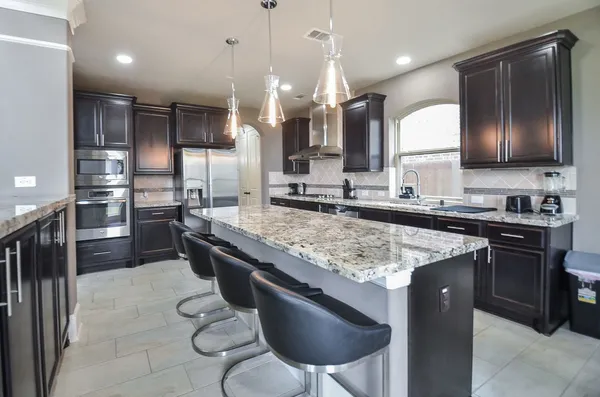 a kitchen with stainless steel appliances granite countertop a sink a stove and a refrigerator