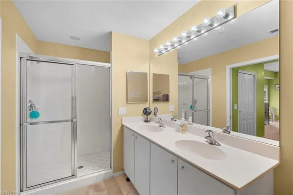 a bathroom with a double vanity sink mirror and shower