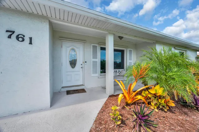 a view of a swimming pool with a table and chairs under an umbrella