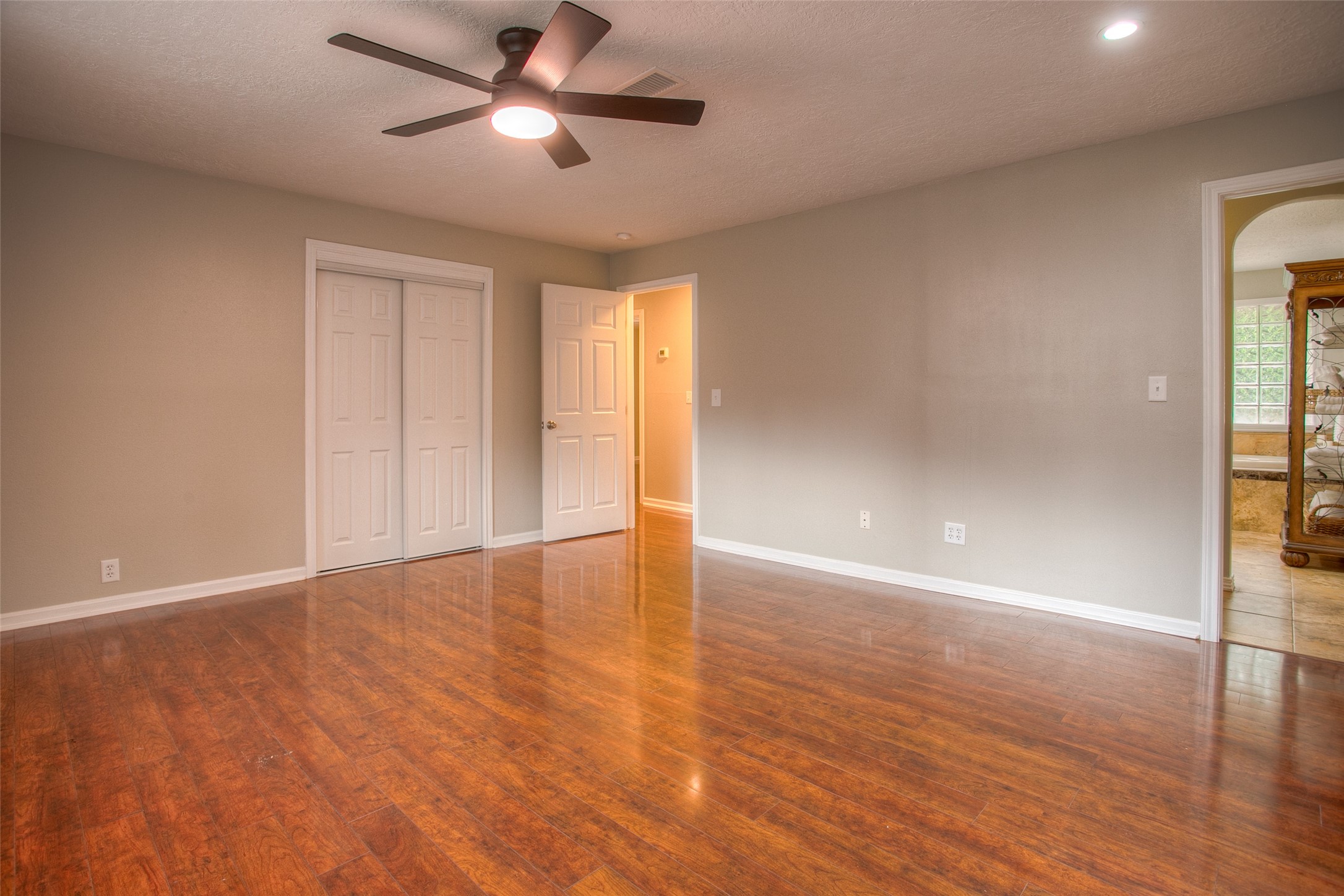 6016 Teas Nursery Road Conroe, TX 77304 - Photo 21 of 50 Primary bedroom features new ceiling fan, laminate wood flooring, and fresh paint.
