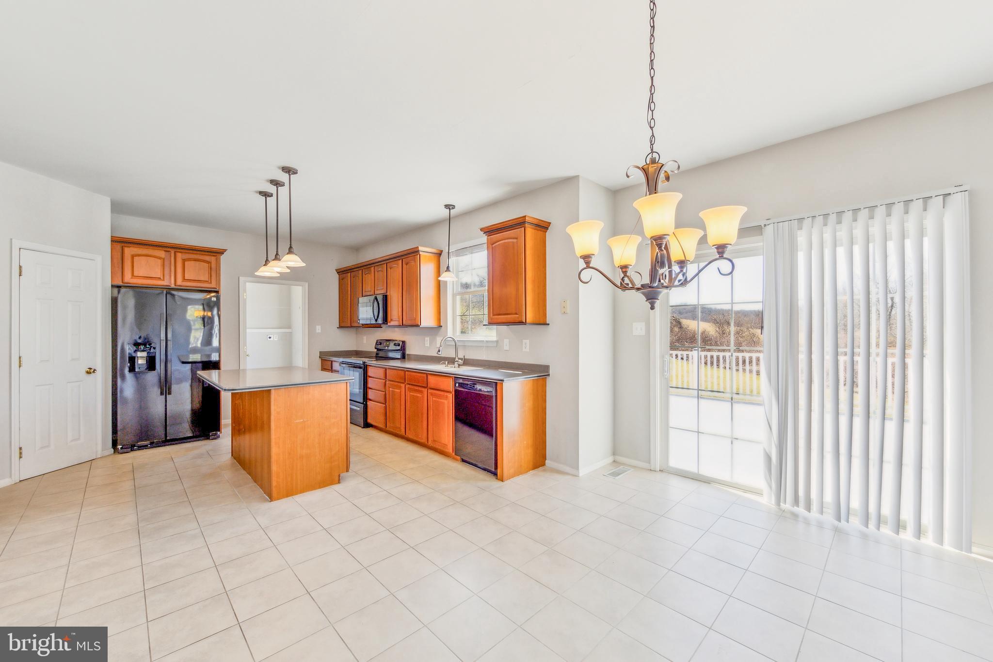 602 Cattail Road Atglen, PA 19310 - Photo 12 of 44 a large kitchen with stainless steel appliances kitchen island granite countertop a refrigerator a stove a sink dishwasher and white cabinets with wooden floor