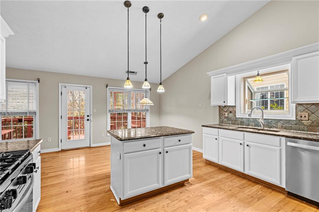 3360 Ennfield Lane Duluth, GA 30096 - Photo 3 of 38 a kitchen with stainless steel appliances granite countertop a sink and cabinets with wooden floor