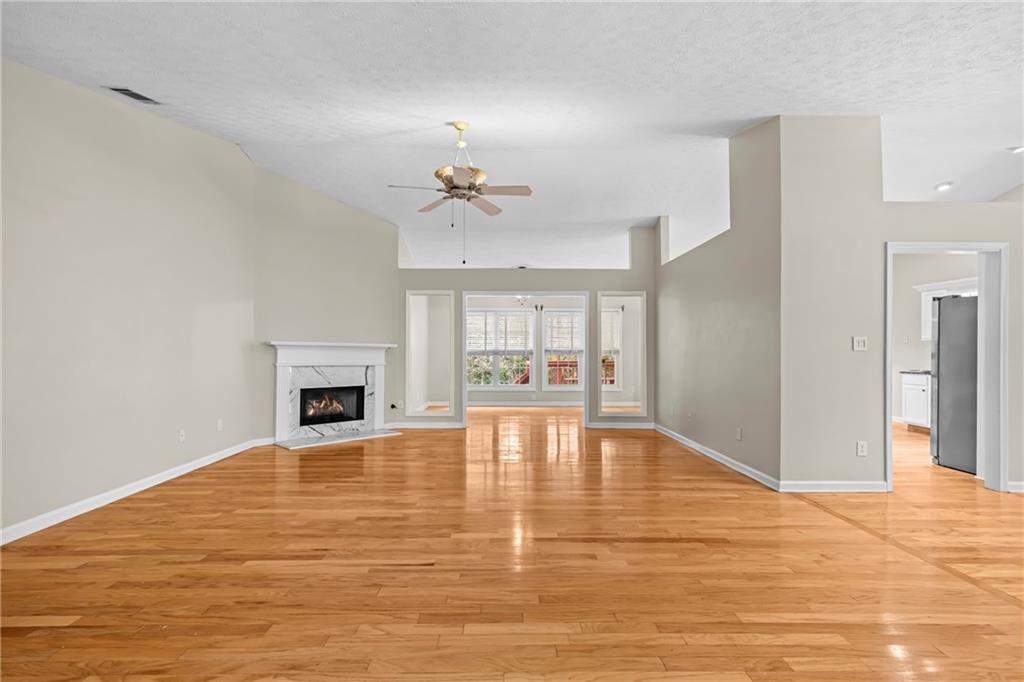 3360 Ennfield Lane Duluth, GA 30096 - Photo 4 of 38 a view of empty room with wooden floor and fireplace