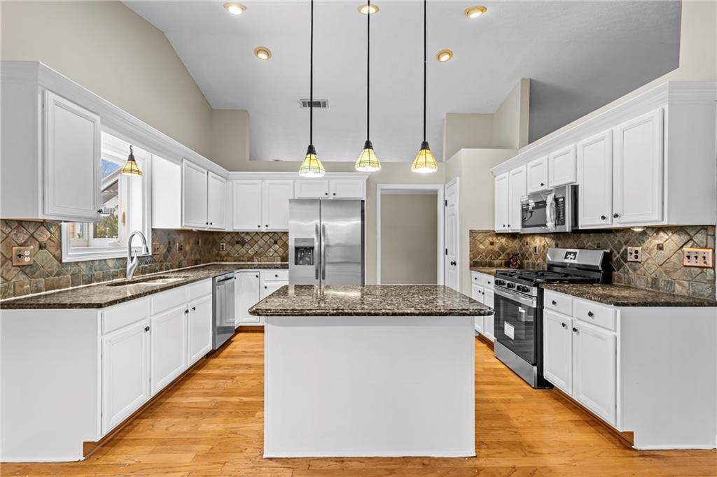 3360 Ennfield Lane Duluth, GA 30096 - Photo 8 of 38 a large kitchen with stainless steel appliances kitchen island granite countertop a stove a sink dishwasher and a refrigerator